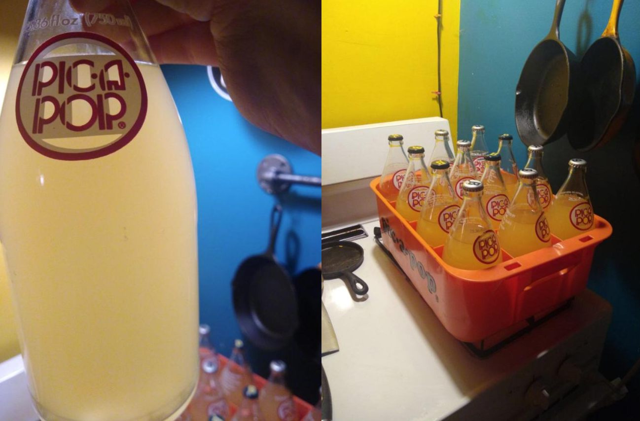 Two photos. Left: Light shines through a filled bottle of finished product. Right: the retro orange plastic Pic-a-Pop crate filled with sealed bottles of faint yellow cloudy liquid