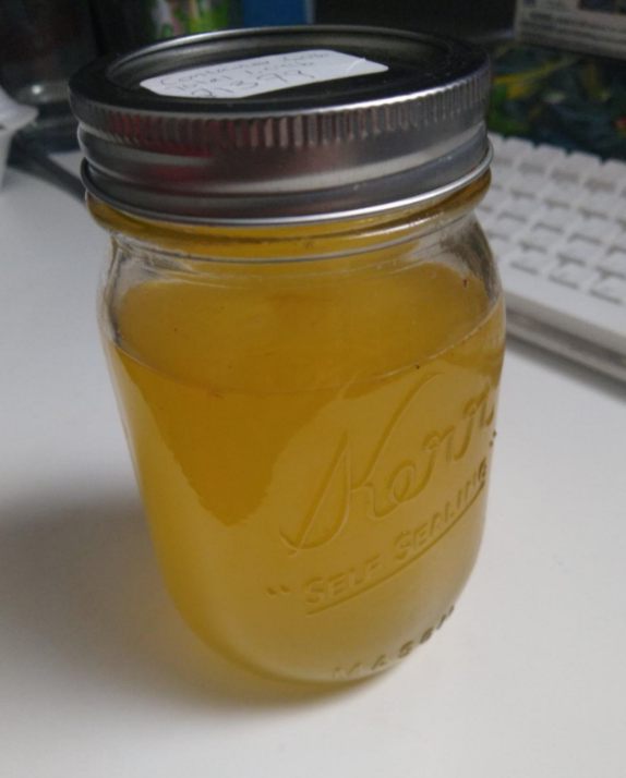 A clear glass jar of yellow sugar & grapefruit peel extract syrup